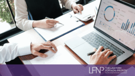Two nonprofit professionals review financial reports and budget charts on a laptop while discussing public charity compliance and IRS reporting requirements. LFNP branding displayed at bottom of image.