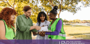 Volunteers meeting in a park reviewing documents together, supported by The Law Firm for Non-Profits.